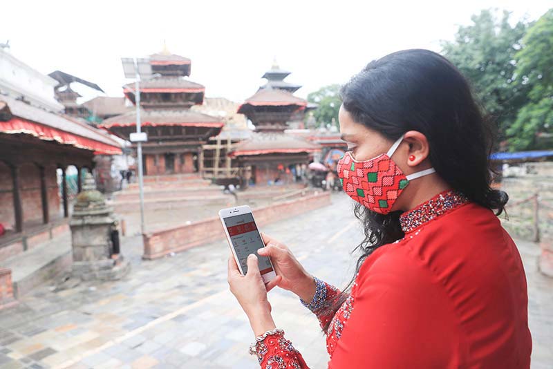 A customer in Lalitpur, Nepal uses a mobile banking app to check her balance.