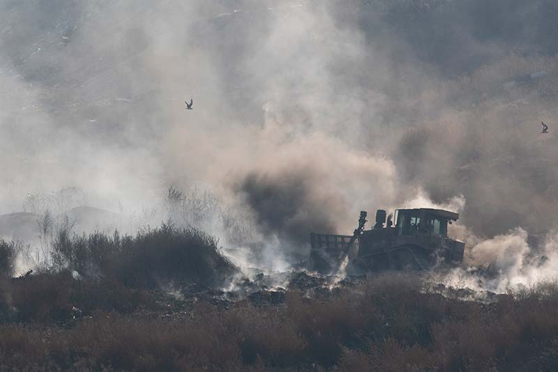 Bulldozers attempt to stamp out burning waste in the Vinča landfill in Belgrade, Serbia.
