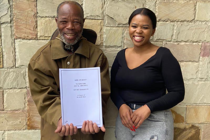 Sifunda Amos Nkosi (left) from Sundumbili B was happy to receive his title deeds.